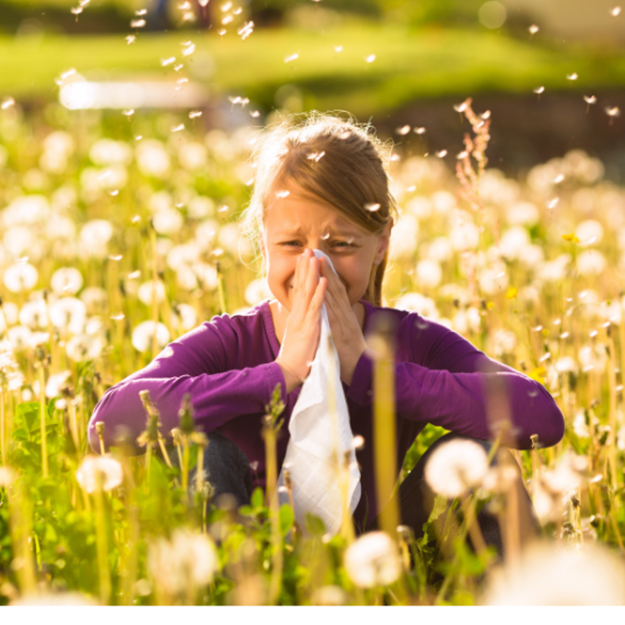 Kind niezend in gras met zakdoek