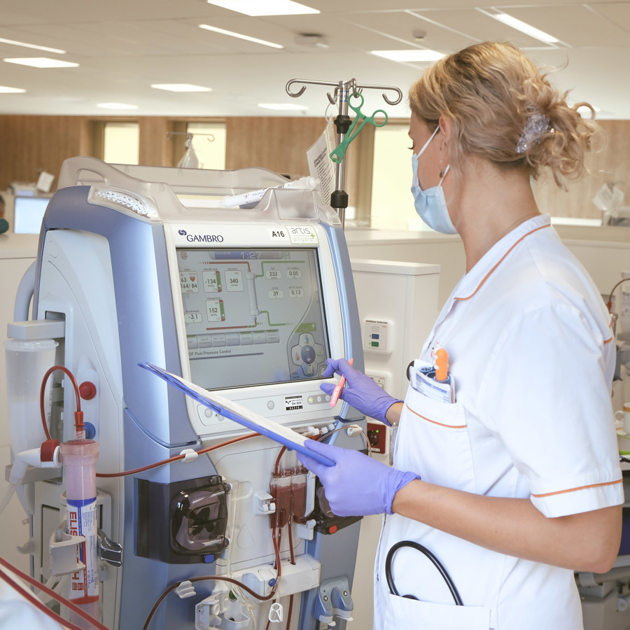 Dialyseverpleegkundige controleert gegevens op dialyseapparaat
