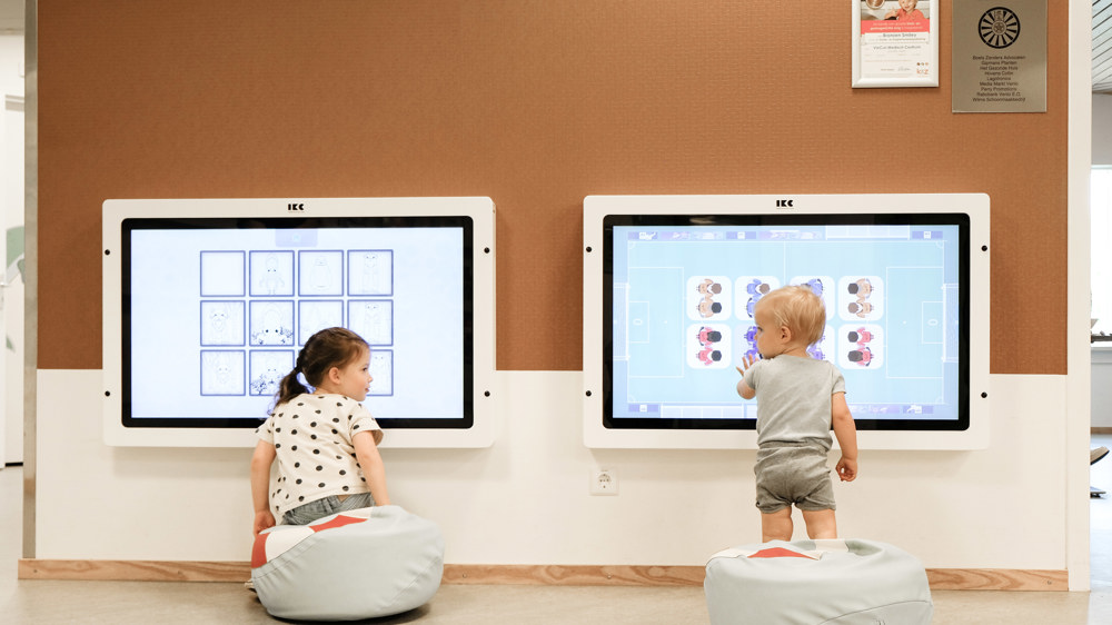 2 kinderen spelen op het digiboard