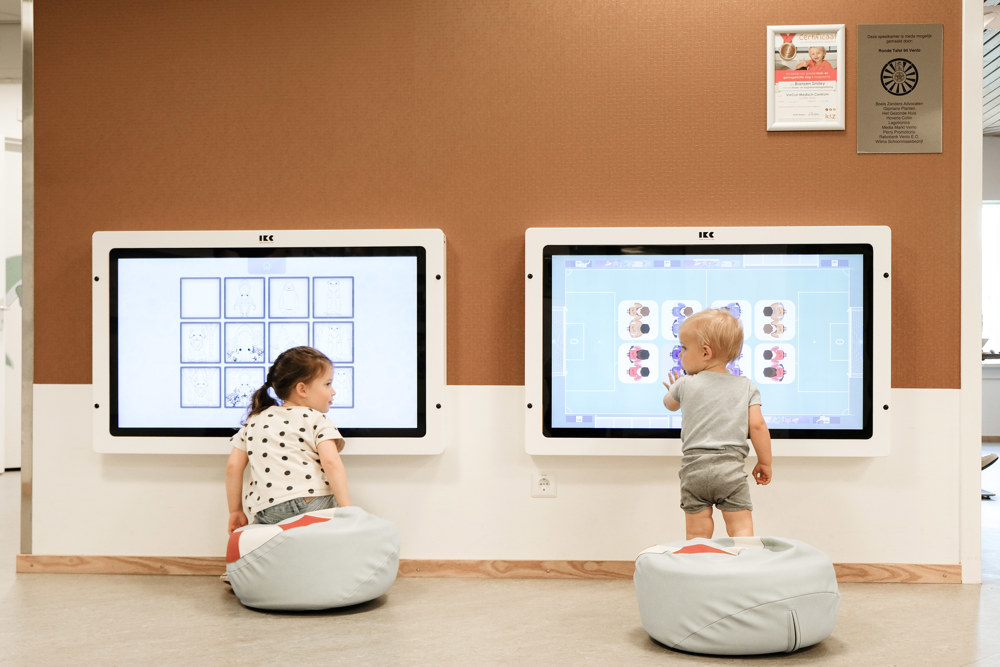 2 kinderen spelen op het digiboard