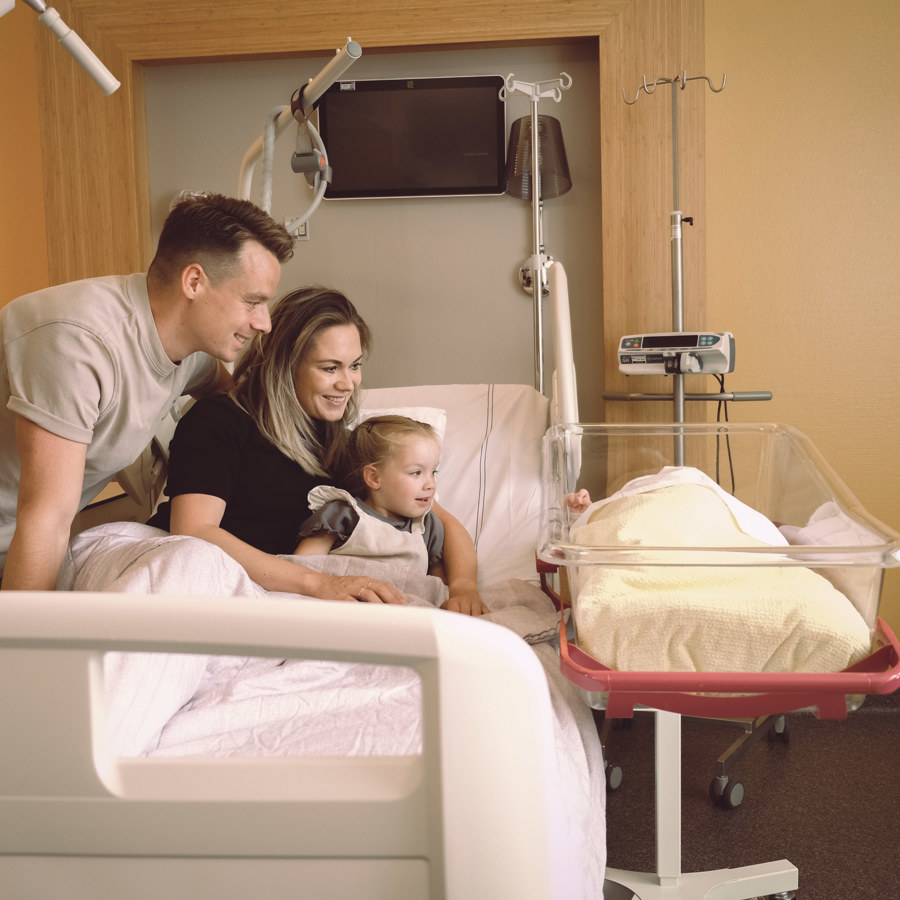 Gezin met pasgeboren baby in bed in Geboortecentrum Noord-Limburg