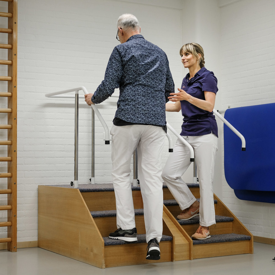 fysiotherapeut oefent met patiënt in oefenruimte