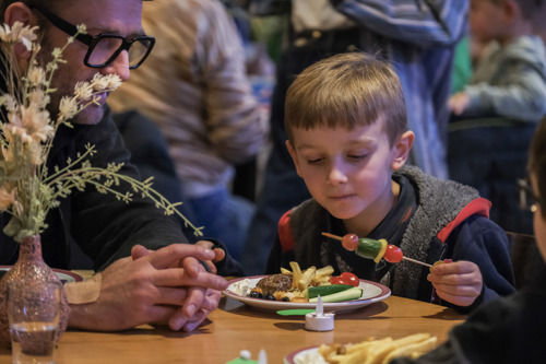 Jongetje aan tafel eet van allergeenvrij buffet.